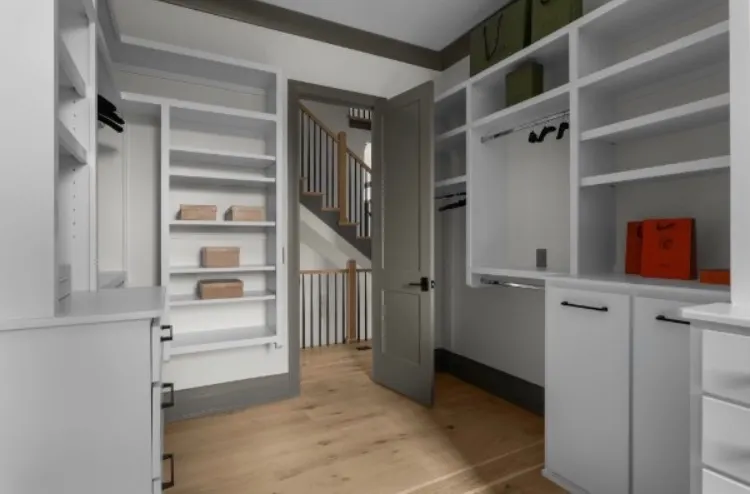 Custom walk-in closet with painted shelving and gray trim accents