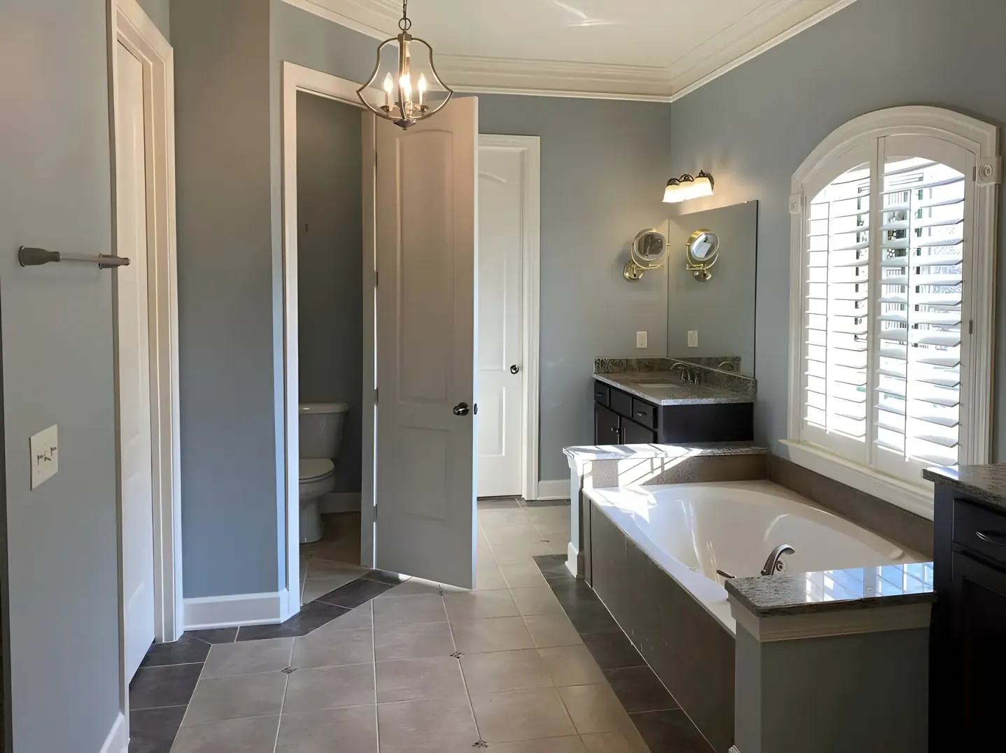 Primary bathroom with blue-gray walls, painted doors and white crown molding, one of our interior painting projects for Bellevue homes