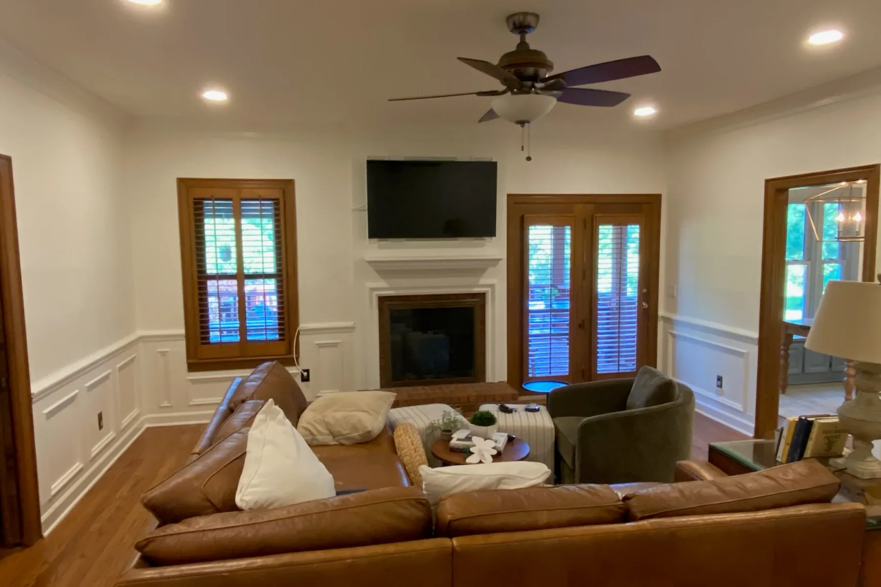 Living room with wainscoting, crisp white trim and a painted fireplace surround, one of our interior painting projects for Bellevue homes