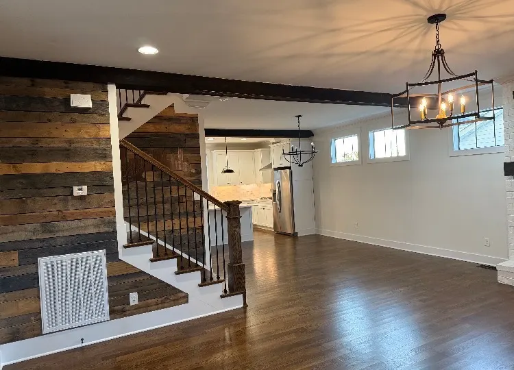 Rustic open concept living area with reclaimed wood accent wall and fresh white paint