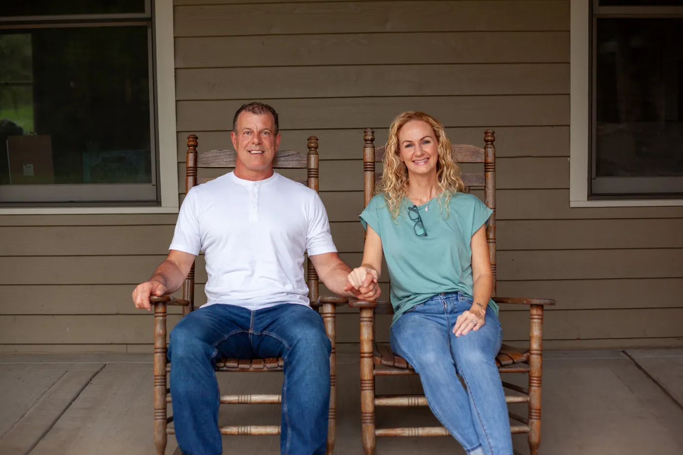 Alan Robinson and his wife Beth sitting together in rocking chairs on their front porch