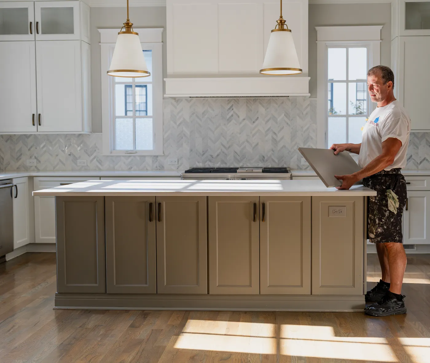 Alan Robinson setting a freshly finished cabinet door on the island of a Nashville kitchen