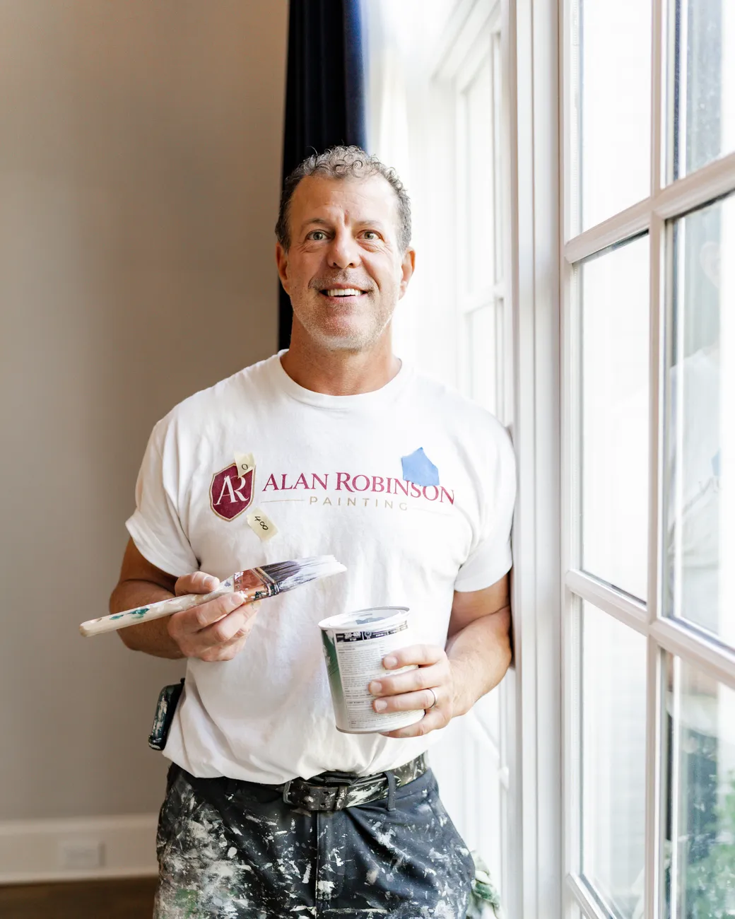 Alan Robinson — Nashville house painter and professional fine artist — with brush and paint can on a job site